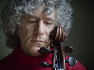 Foto von Steven Isserlis – Nahaufnahme vom Gesicht des Cellisten, der seine Wange gegen die Schnecke seines Cellos hält und nach unten blickt