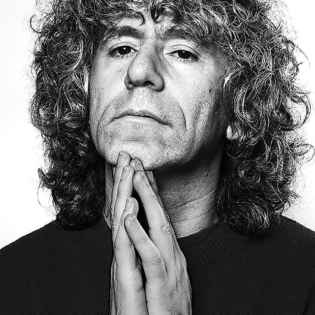 Foto von Steven Isserlis – schwarz-weiss-Porträt des Cellisten mit markanten Locken, nachdenklich mit gefalteten Händen in die Kamera blickend.