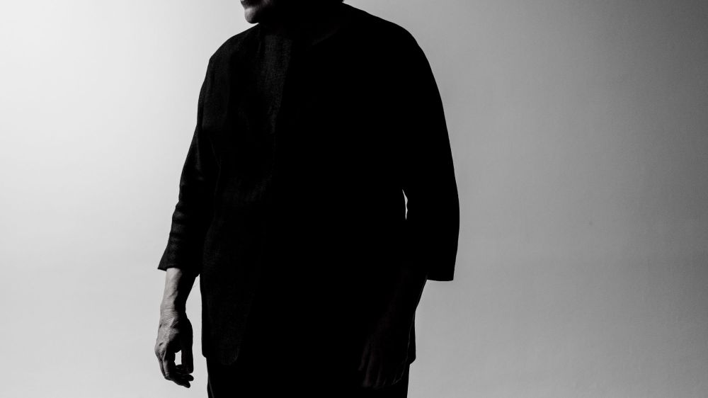 Foto von Elisabeth Leonskaja – Schwarzweissbild der Pianistin, die vor einem  Grauen Hintergrund steht und zur Seite blickt, man sieht beinahe nur ihre Silhouette