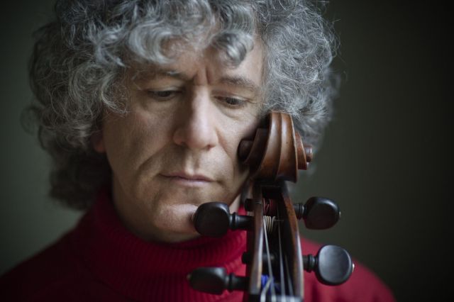 Foto von Steven Isserlis – Nahaufnahme vom Gesicht des Cellisten, der seine Wange gegen die Schnecke seines Cellos hält und nach unten blickt