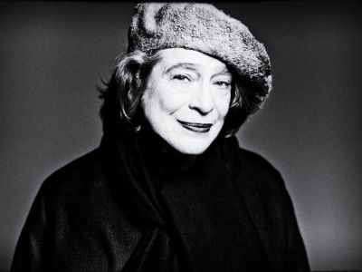 Foto von Elisabeth Leonskaja – Schwarzweissbild der Pianistin, die vor einem  Grauen Hintergrund steht und zur Seite blickt, man sieht beinahe nur ihre Silhouette